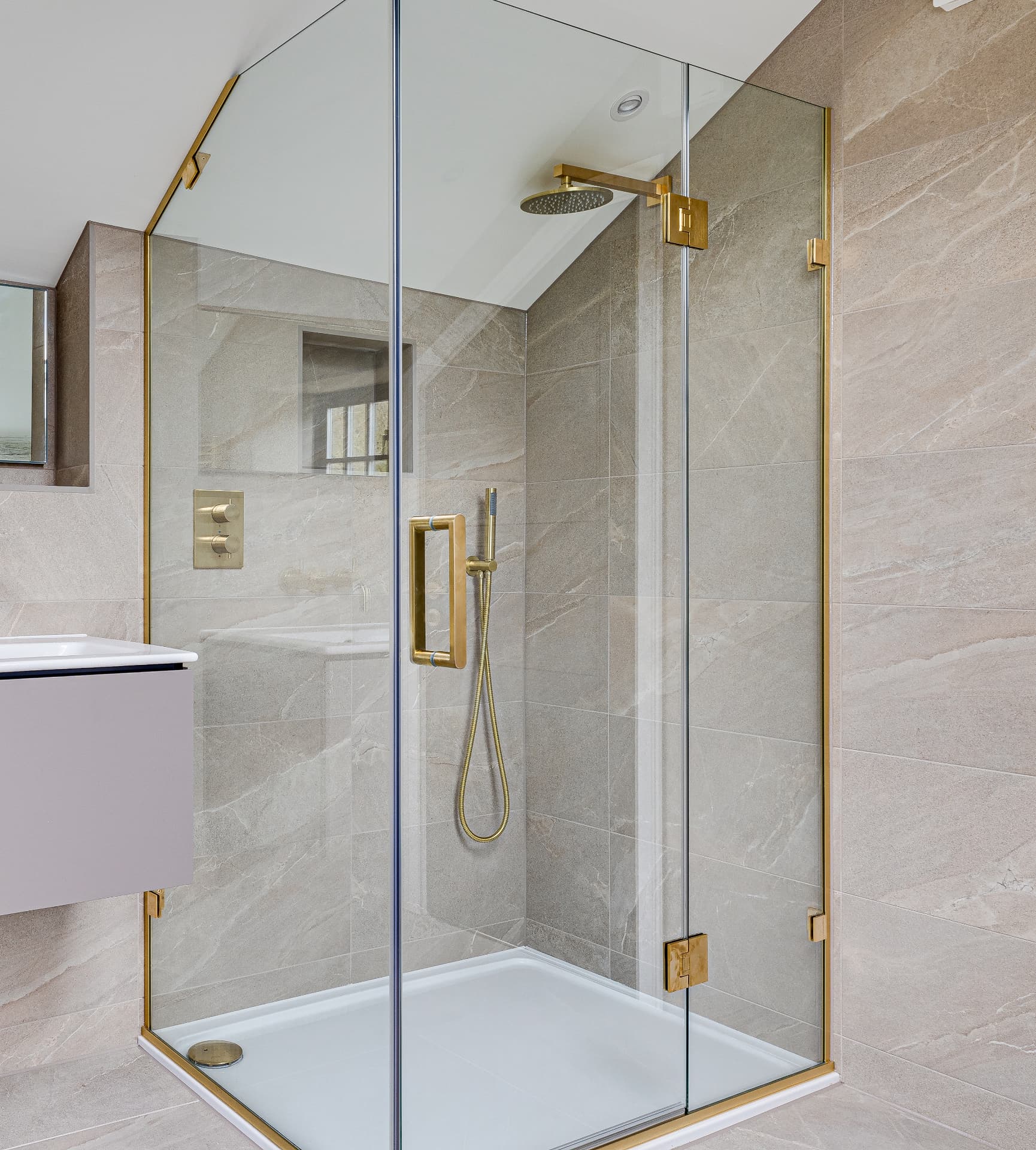 Shower room with brass fittings and grey marble tiling at Old Hall